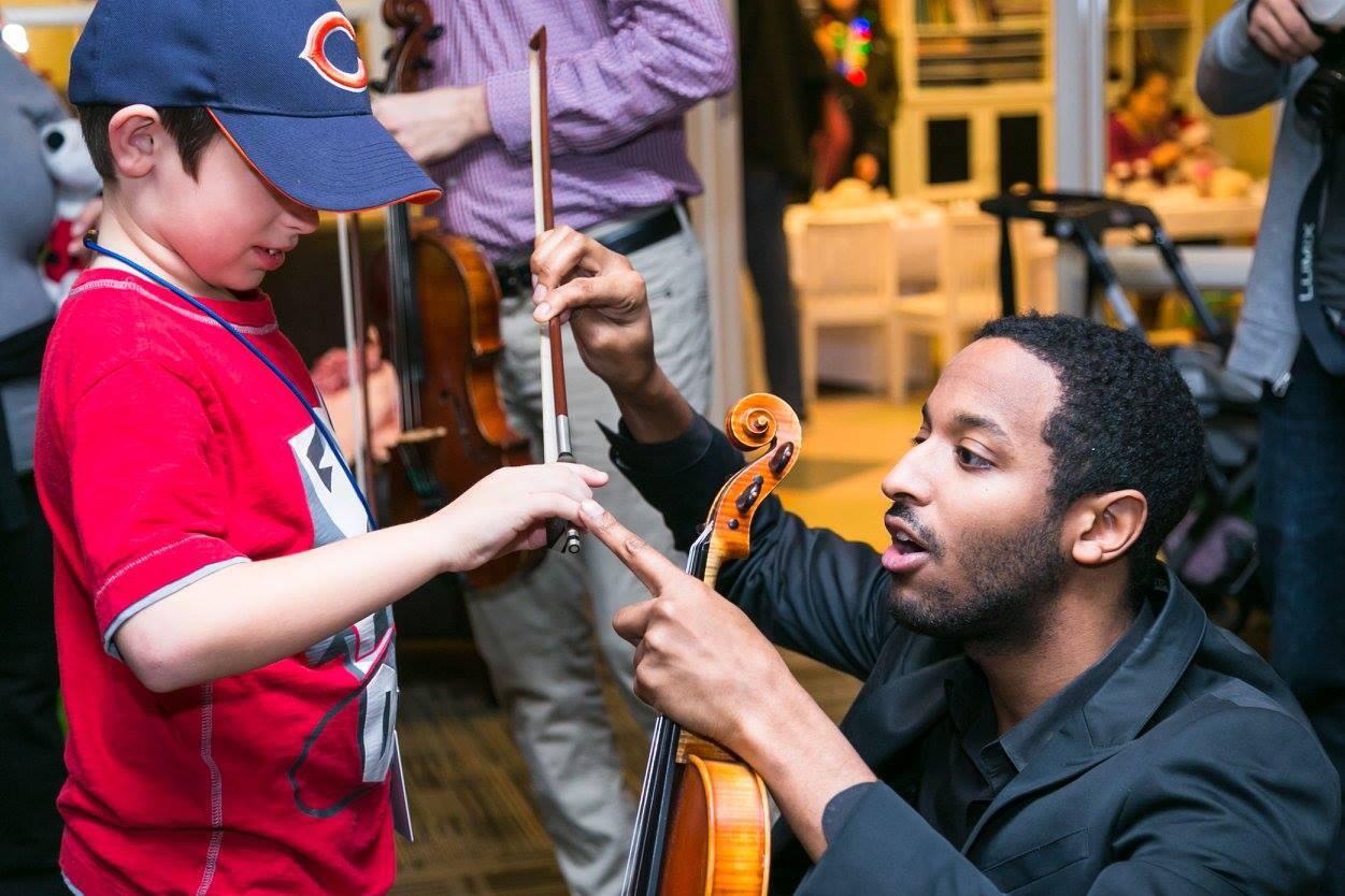 Kyle Dickson coaches a young violinist