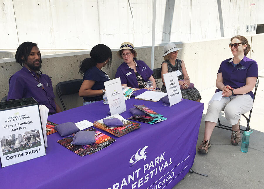 Grant Park Music Festival volunteers and docents gather at the welcome tent